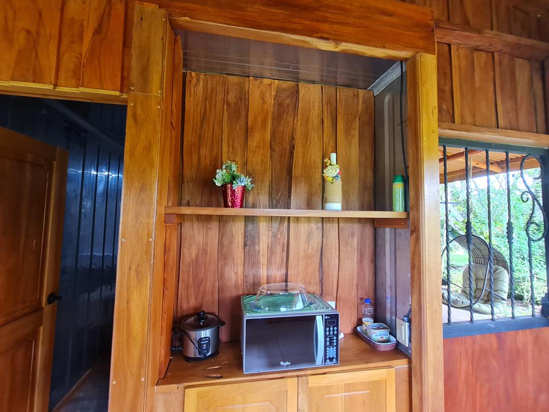 Cocina compacta y funcional de la cabaña Eco Container con acabado de madera.